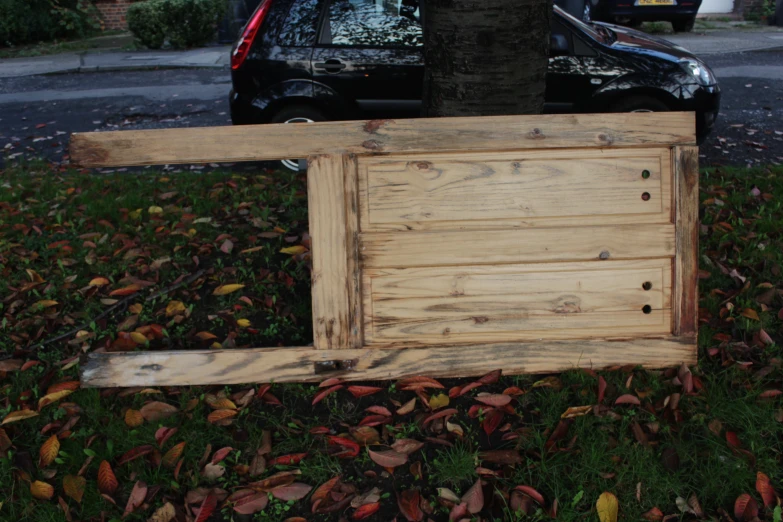 a wooden frame sitting on the ground with leaves