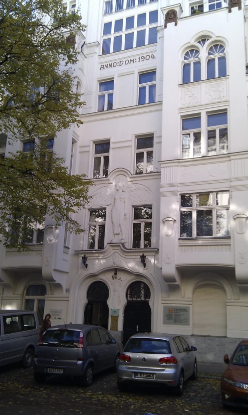 three different cars parked in front of an old building