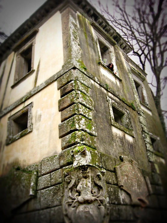 an old, dilapidated building with two windows and peeling paint