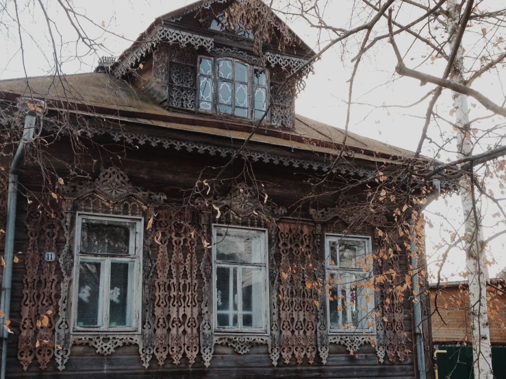 an old wooden house sitting on a street side