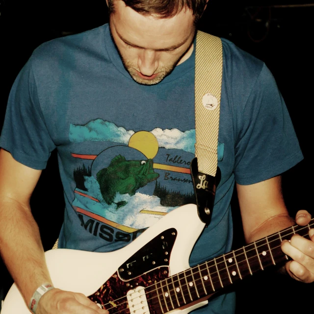 a man playing a guitar while standing up