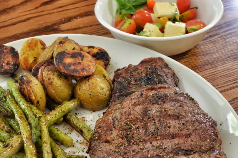 the steak is served on the plate with potatoes and asparagus