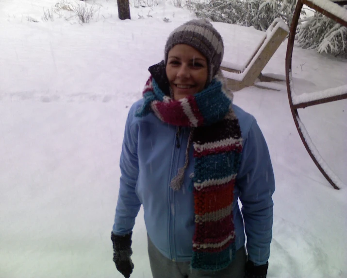 a woman is in the snow with a knit scarf