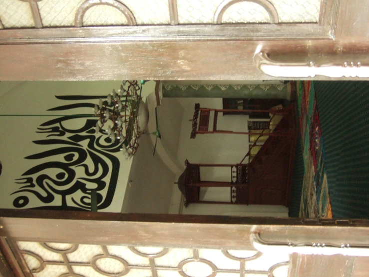 a mirror reflecting a room with ornate wall and ceiling designs