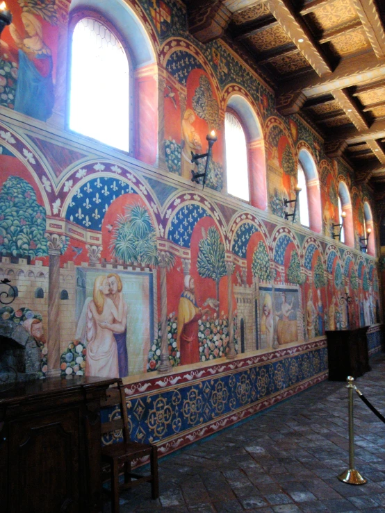 a large mural by a window is in the middle of a long room