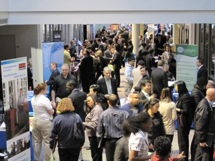 crowd of people walking through convention hall and exhibit