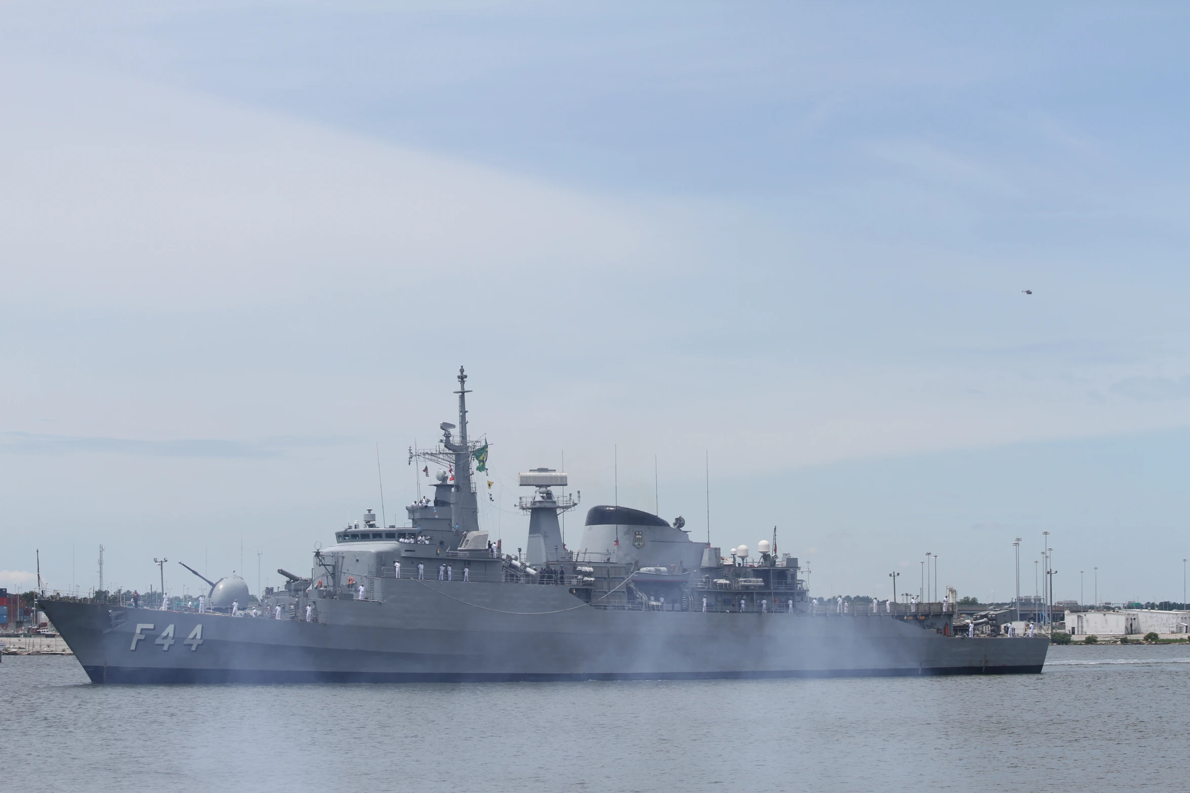 a navy boat on the water with smoke pouring from it