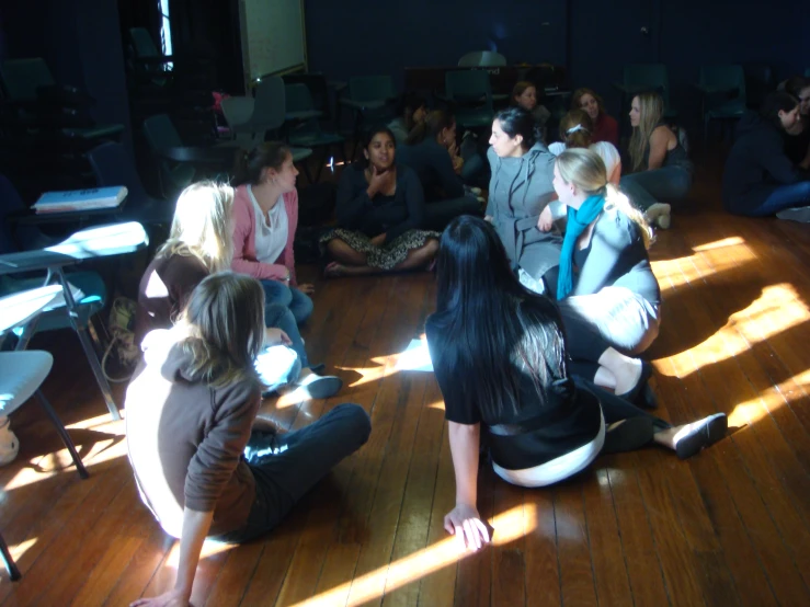 a group of people sitting on the floor in front of a crowd