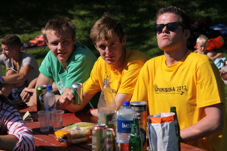 several men sitting around at an outdoor table