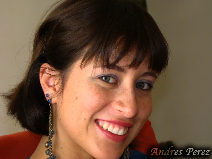 a woman wearing earrings smiles for the camera