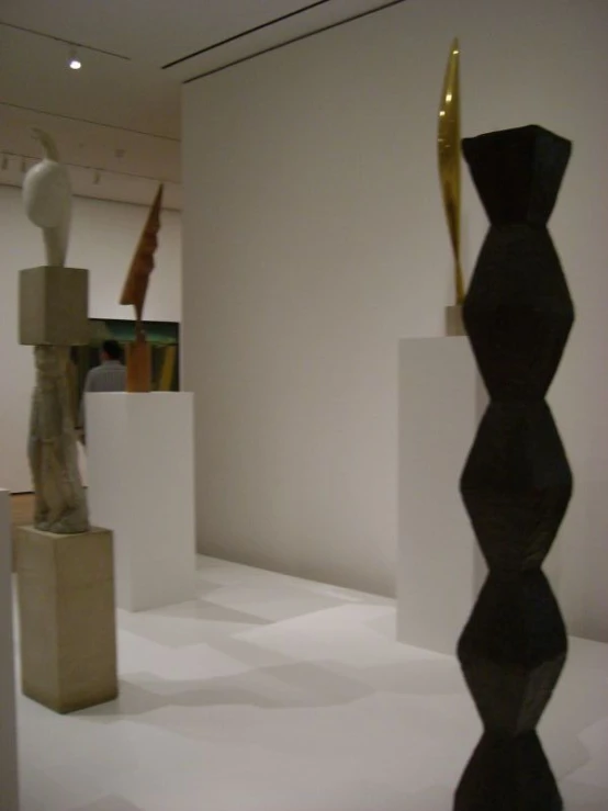 two sculptures on display in a room with white walls