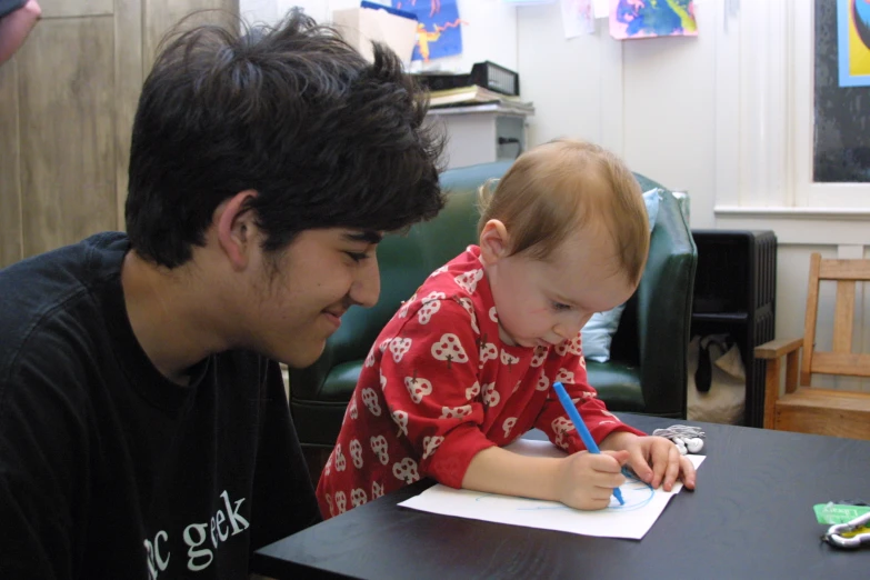 the child is sitting at a desk, doing his homework