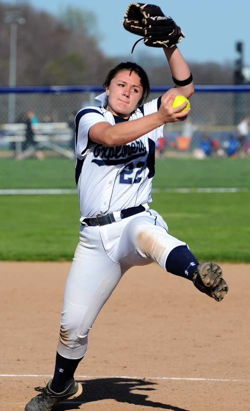 a girl throwing a softball from the mound