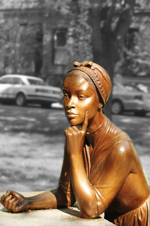 black and white pograph of bronze statue of woman looking up