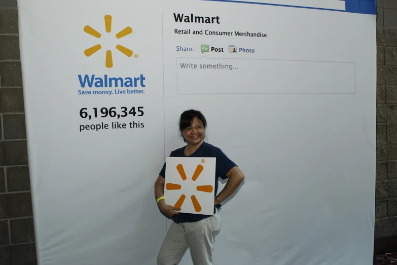 a person standing by a sign with a picture of herself