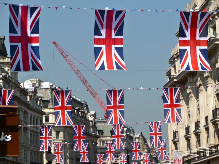 several british flags being hung from the sides of buildings