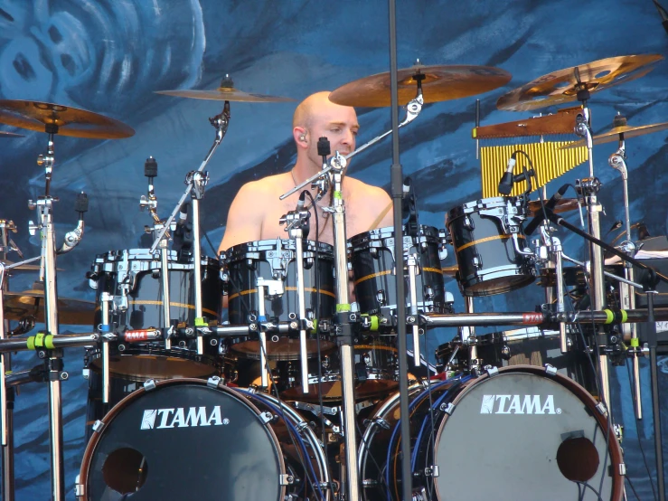 the drummer with a shaved head playing drums