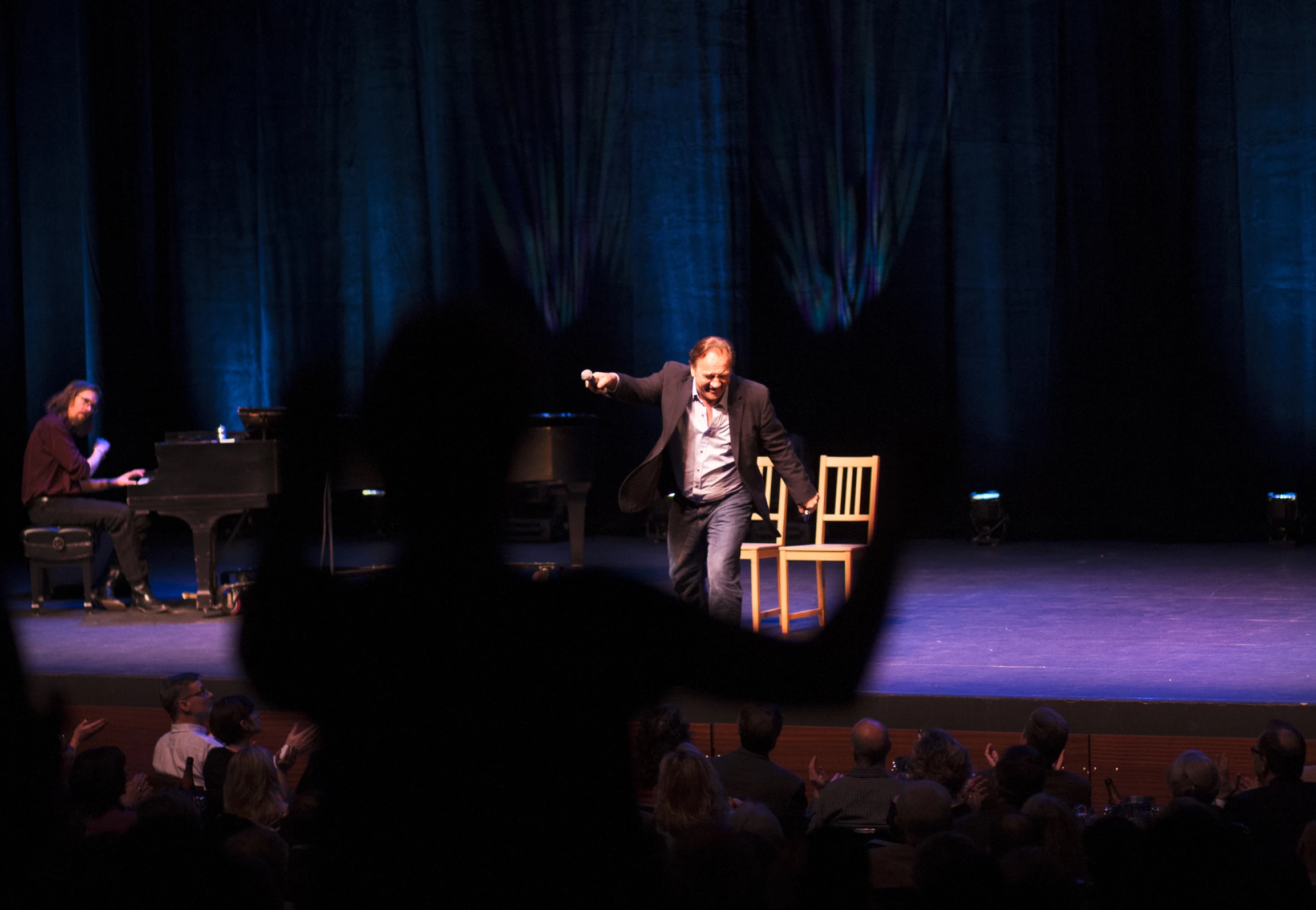 a stage with many people and two men on it