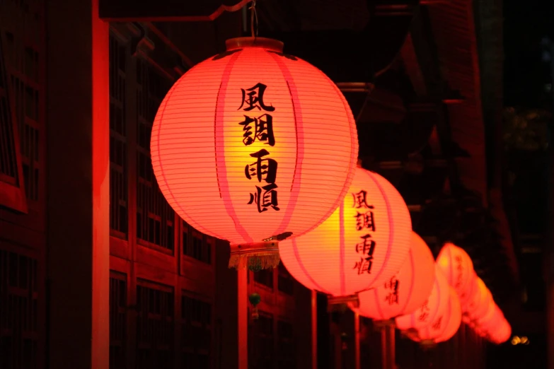 lanterns lit up in chinese words are displayed on the street