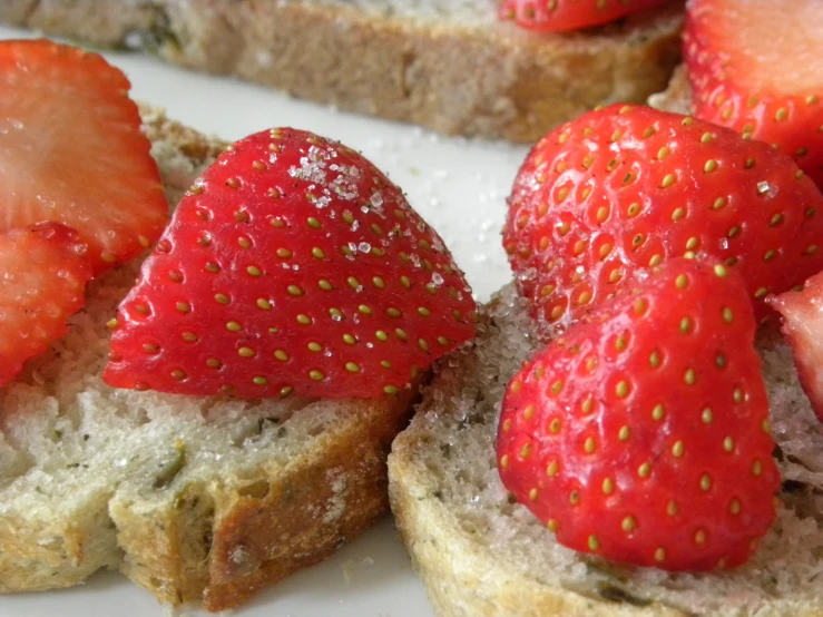 three slices of toast are topped with strawberries