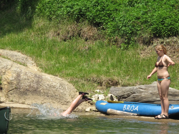 two people stand in water near the shore