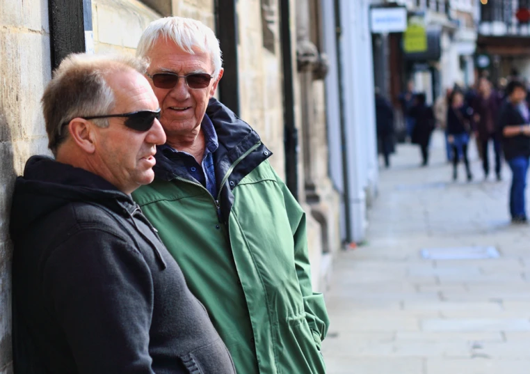 a couple of men standing next to a building