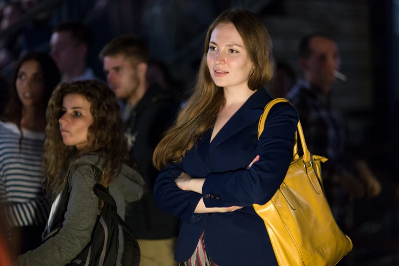 people looking at the camera with purses in front of them