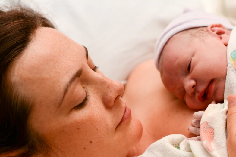 a woman holding a sleeping baby on her back