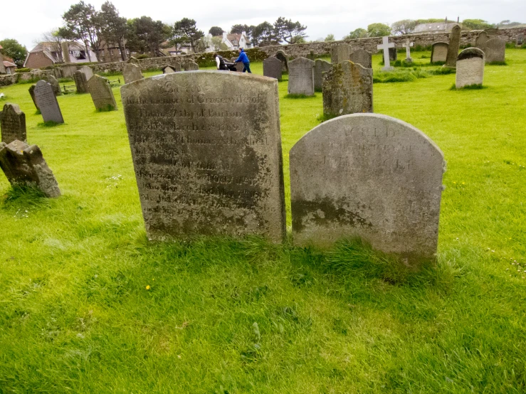 a couple of headstones laying on top of green grass