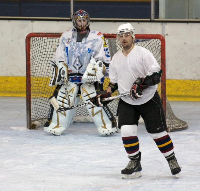 hockey player in white uniform in front of goal