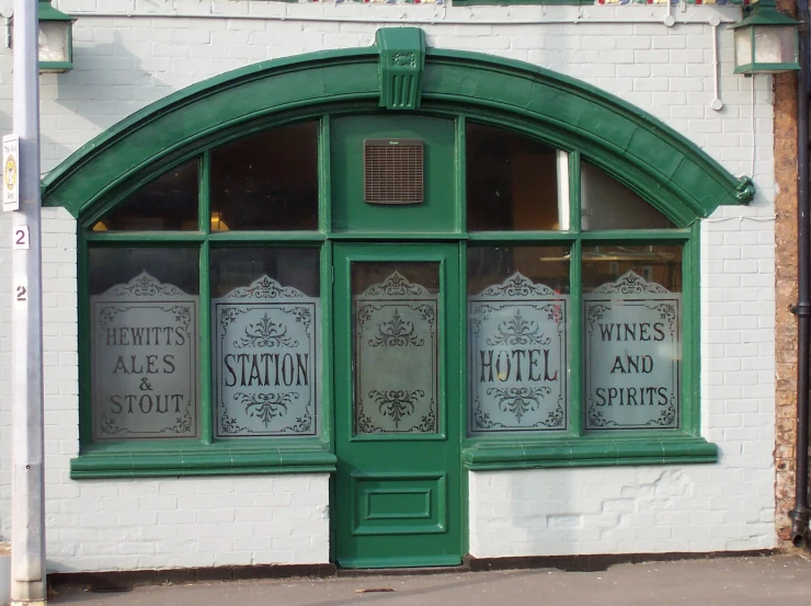 a store front with green doors and ornate design