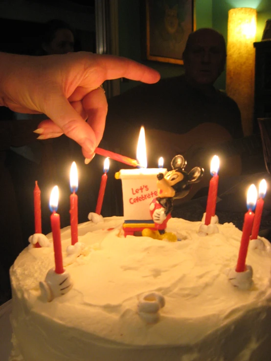 a person lighting candles on top of a cake