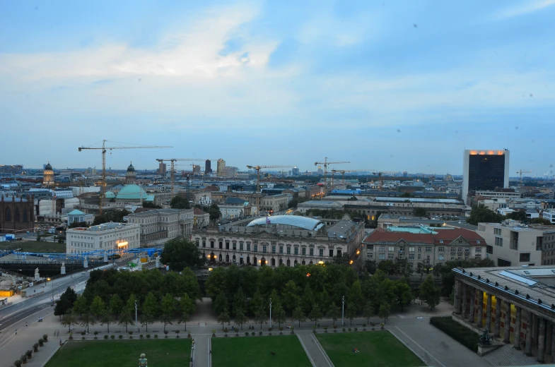 a city with many buildings and cars and lots of green trees