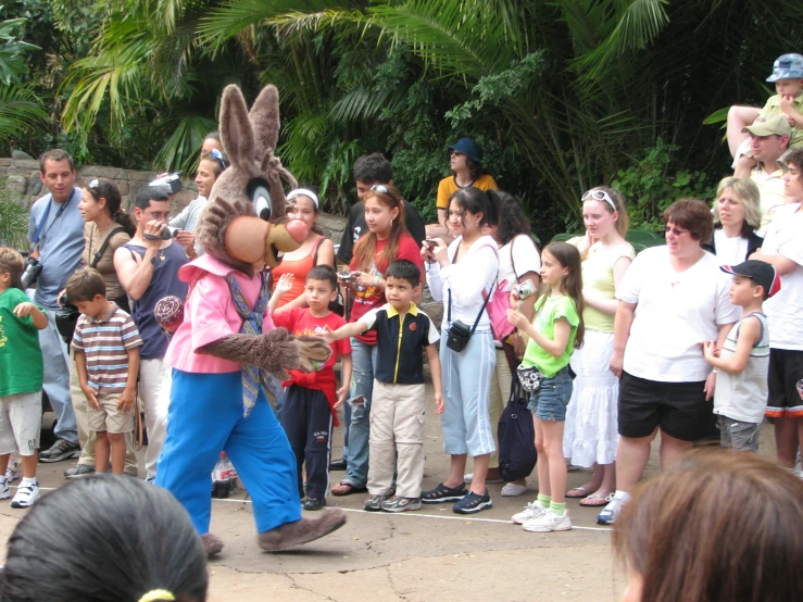 several children watch as adults and a woman perform