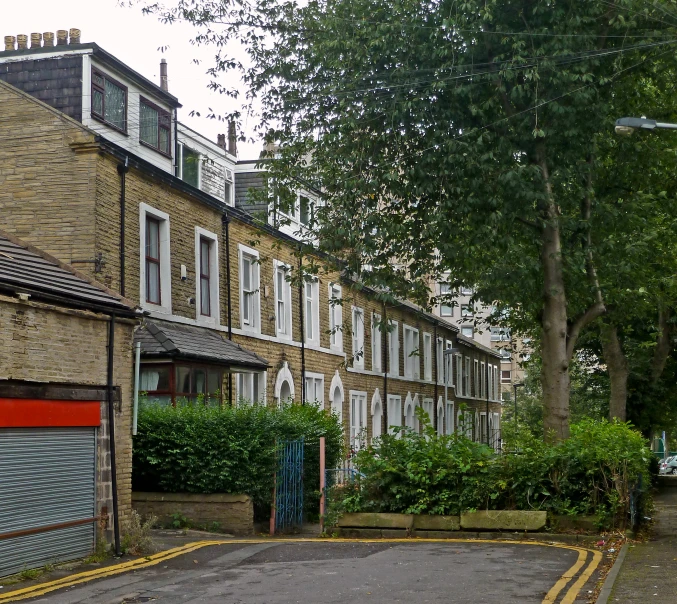 an empty street with brick buildings and garage doors