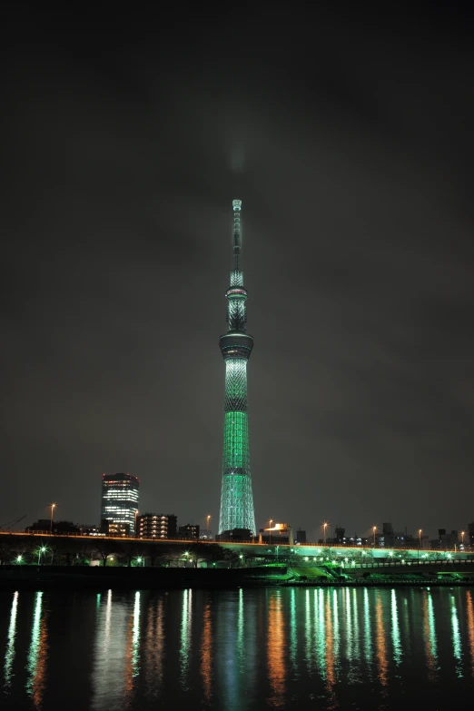 a tall tower is shown lit up green