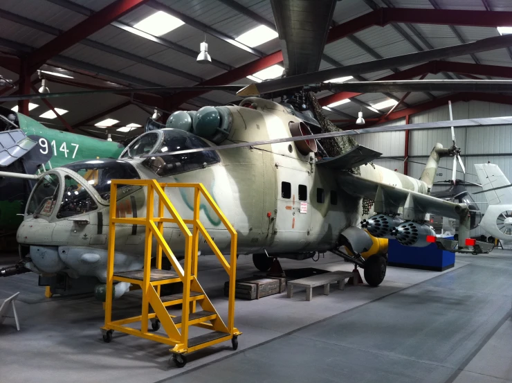 a large propeller plane is on display in a hangar