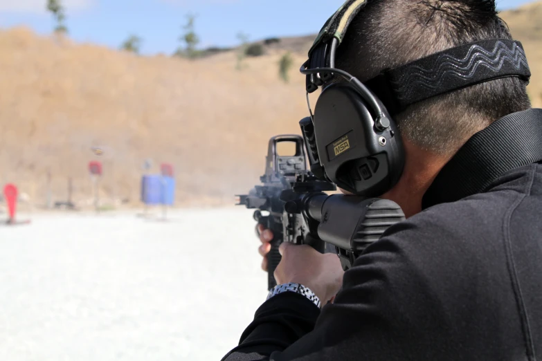a man aiming at a target with a headphone on
