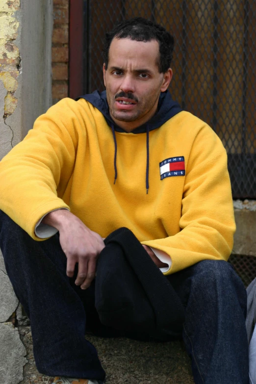 a man sitting on steps with a sweater over his face