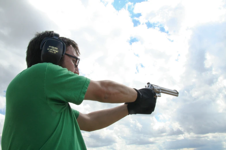 a man in a green shirt is using a gun