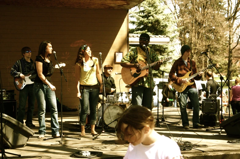 people singing and playing instruments in front of a building