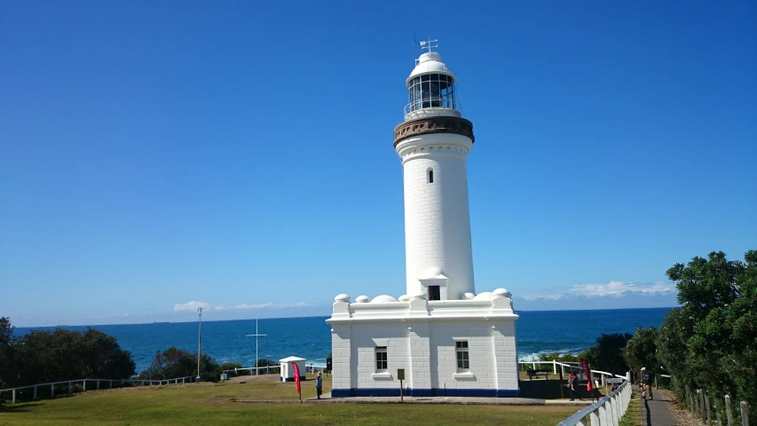 a white lighthouse sitting in front of the ocean