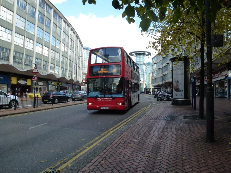 a red double decker bus driving on a city street