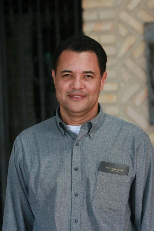 a smiling man wearing a on down shirt