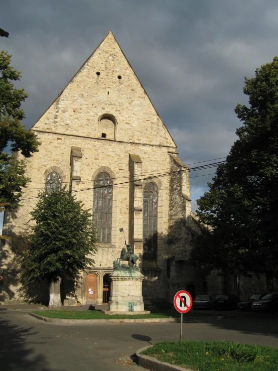 a large stone church has a red sign in front of it