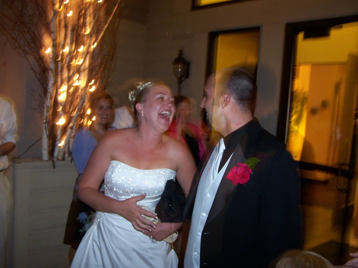 a woman in a white dress standing next to a man wearing a suit