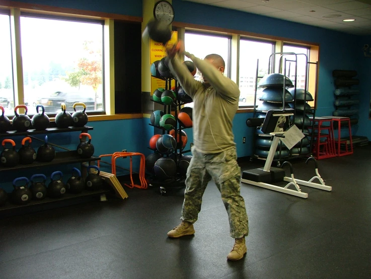 a man lifts a weight ball while he squats