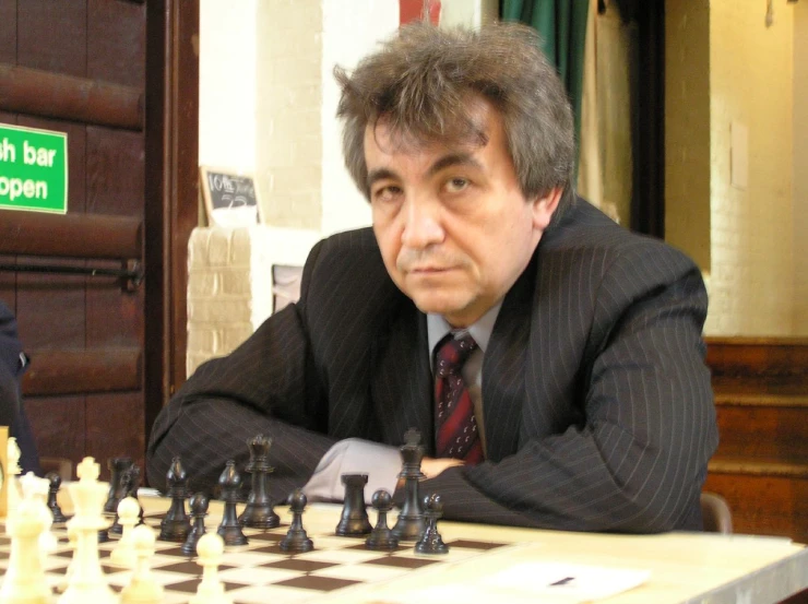 a man sitting at a table playing chess