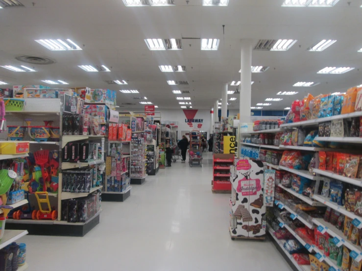 a group of people walking through a shopping center aisle