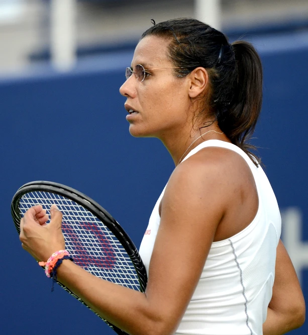 a woman in white holding a tennis racket